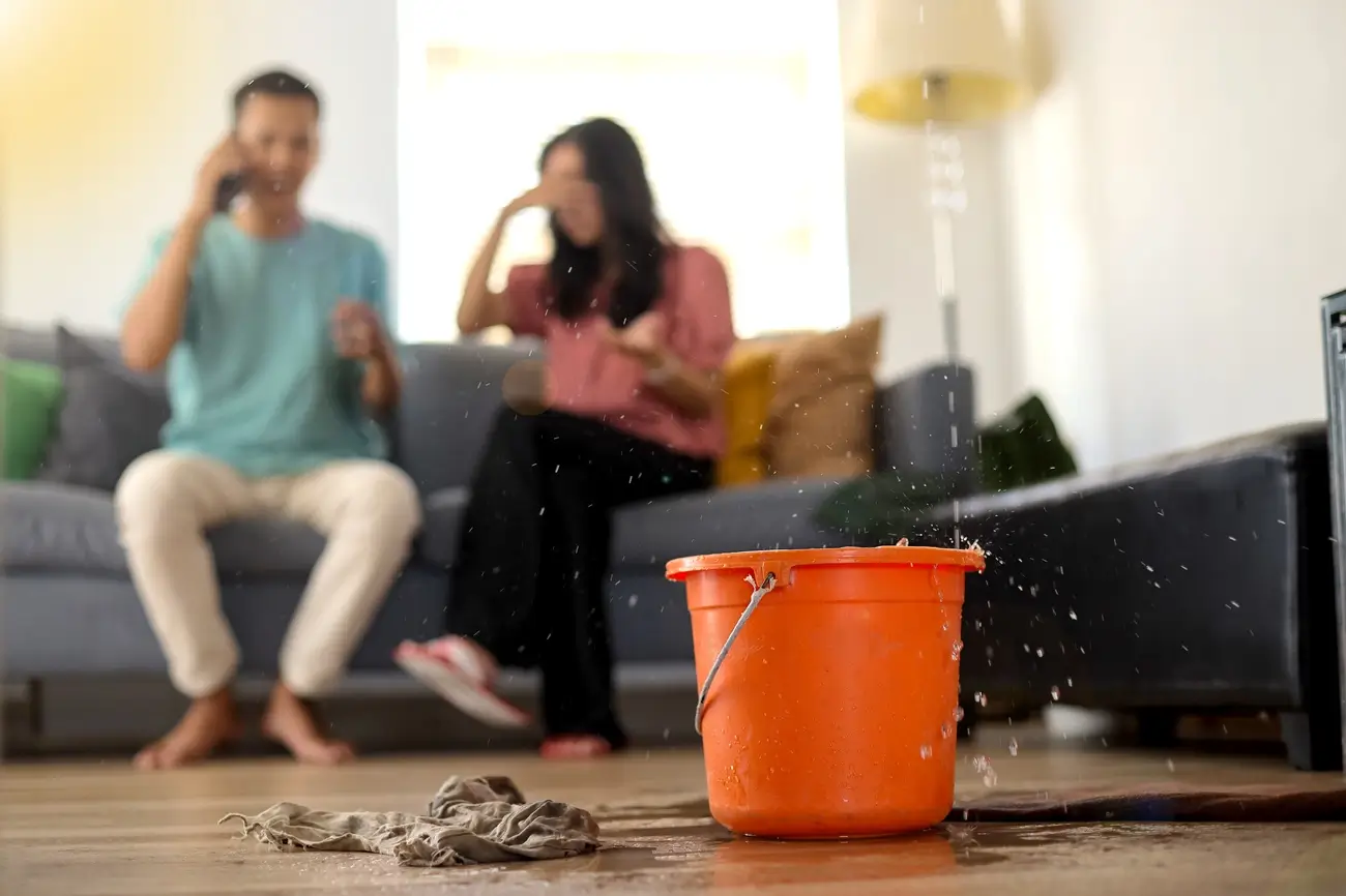 Water drips into buckets in living room due to unnoticed plumbing leak