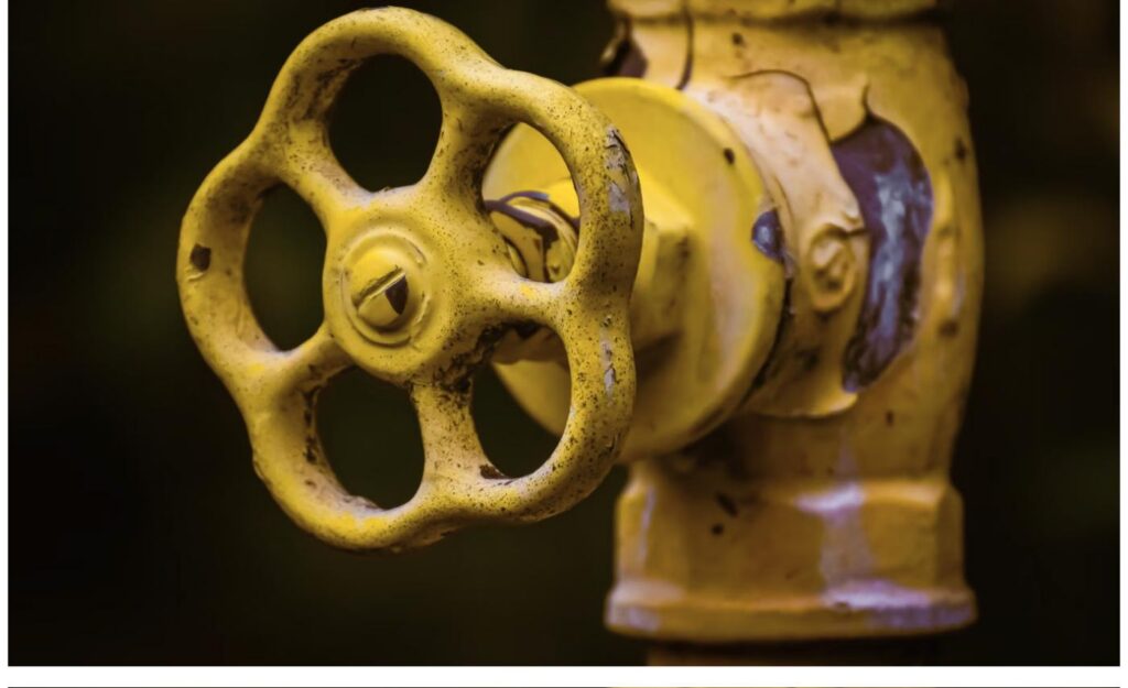 Close-up of a yellow gas shut-off valve on a gas line
