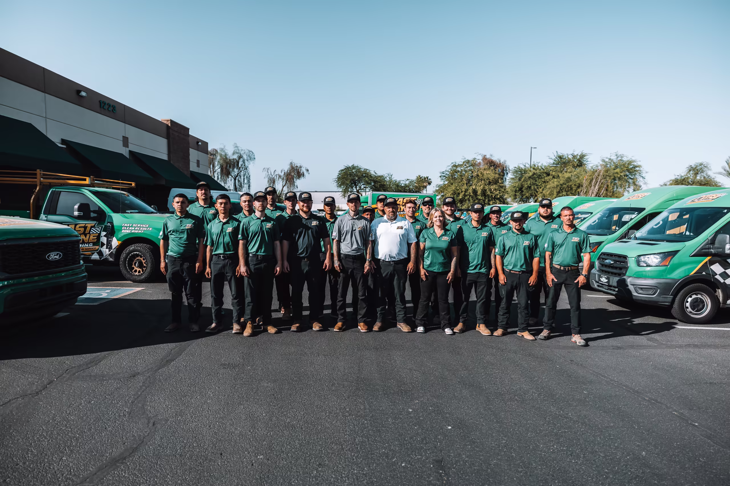 The Fast Layne Plumbing team standing in front of the service fleet